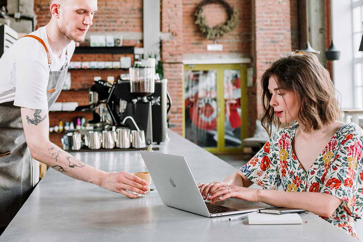 Frau an Laptop sitzt an der Bar