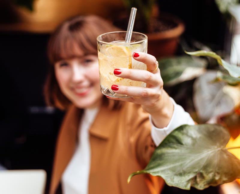 Frau hält Glas zum Anstoßen in der Hand" title="Blog-Gastartikel-Paynoweatlater-Bild3