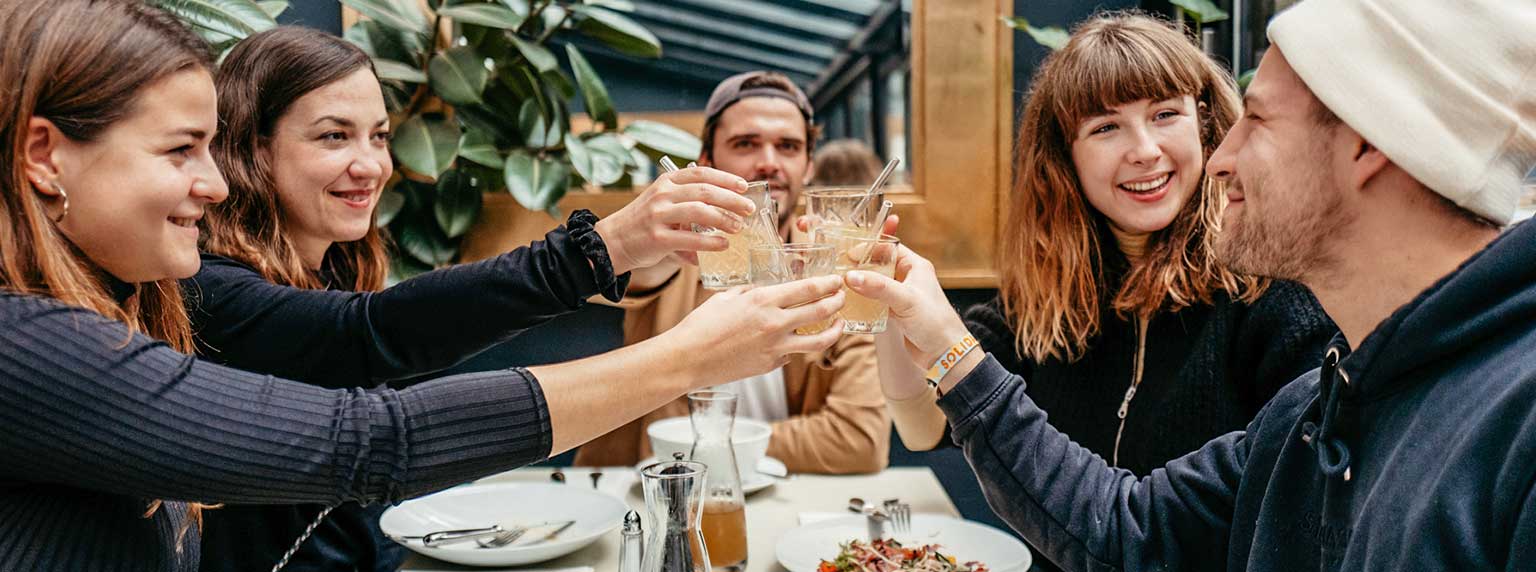 Gutscheine in der Gastronomie: Gruppe von glücklichen Menschen stoßen mit Getränk an: Tipps für Gutscheine in der Gastronomie" title="Blog-Gastartikel-Paynoweatlater-Header