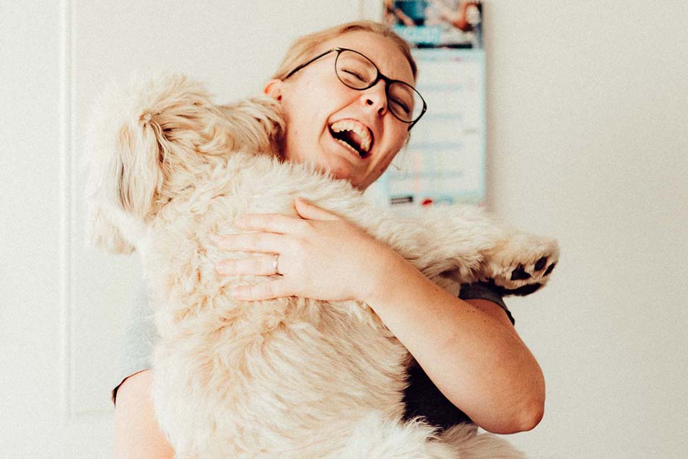 Blonde Frau mit einem Hund auf dem Arm" title="Marie mit Bürohund