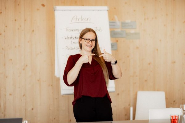 eine Frau hält einen Vortrag und macht mit ihren Fingern Gestiken" title="e2n academy Feedback Seminar mit Franzi