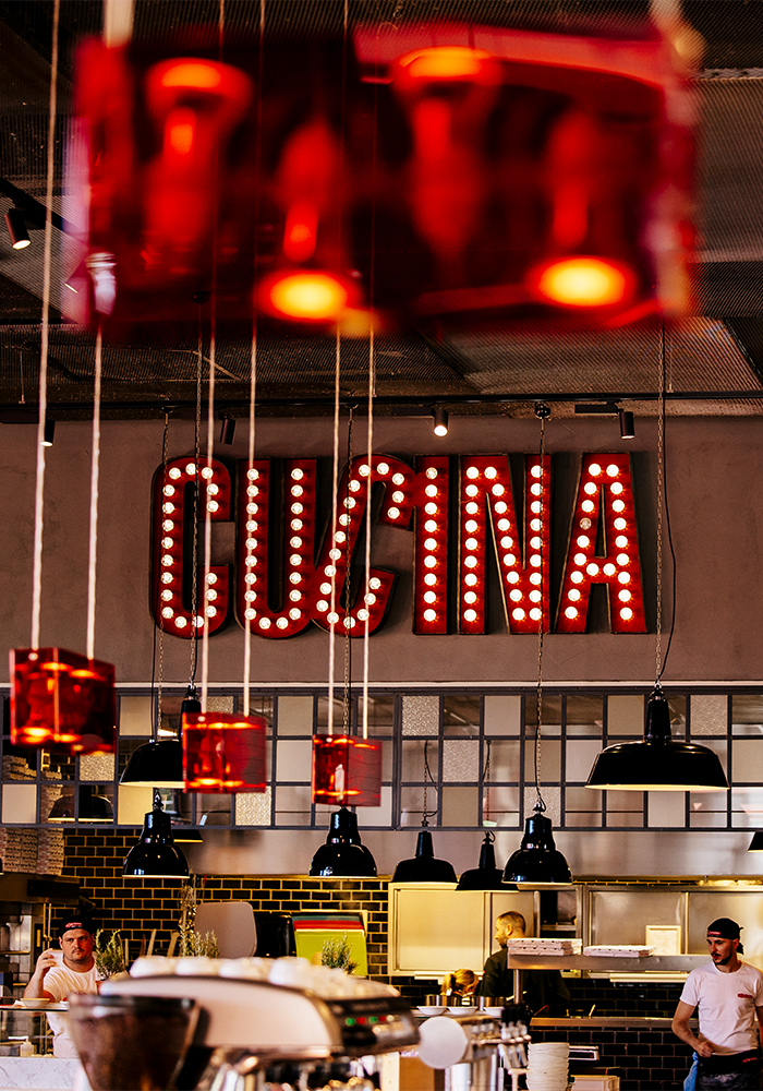 Leuchtschild mit dem Wort "Cucina" in der L'Osteria" title="Blog-SuccessStory-LOsteria-Bild9