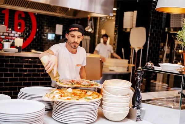 zwei Männer bereiten Pizza in der Küche zu