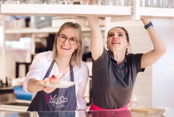 zwei Frauen lächelnd bei der Arbeit