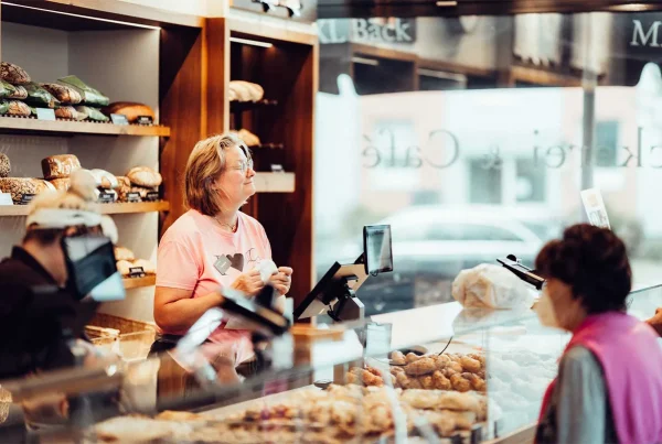 Frau lächelnd hinter der Theke einer Bäckerei